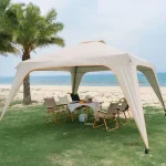 Camping gazebo set up on beach with chairs and table under palm trees