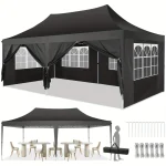 Black camping gazebo with side walls and windows, set up for outdoor dining.