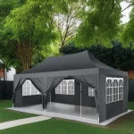 Stylish black camping gazebo with windows set up in a green backyard